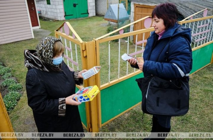 Почтальон Галина Яцкевич оказывает услугу Валентине Домино по приобретению товара с помощью мобильного терминала