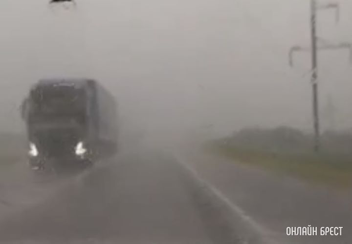 Посмотрите, какой сильный дождь идет в Кобринском районе. Автомобили едут медленно с включенной «аварийкой».